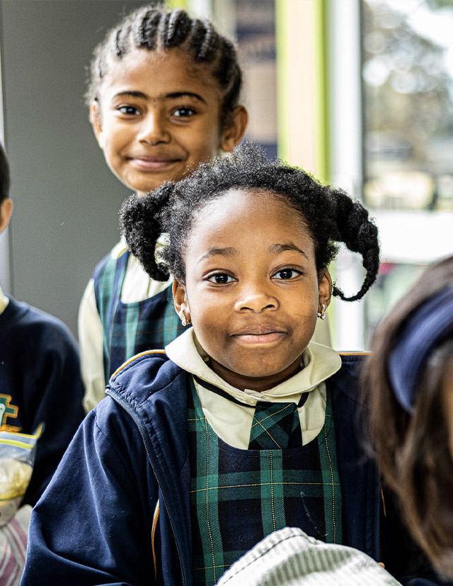 Two girls smiling at St Francis of Assisi Catholic Primary School Glendenning