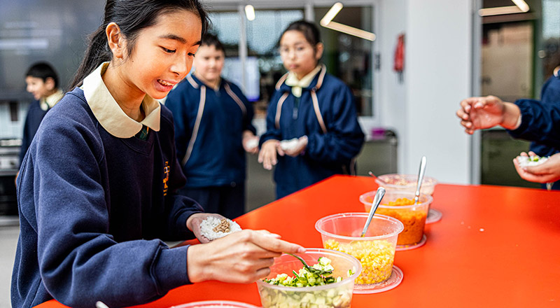 Student using external kitchen at St Francis of Assisi Catholic Primary School Glendenning