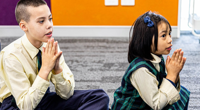 Children praying at St Francis of Assisi Catholic Primary School Glendenning