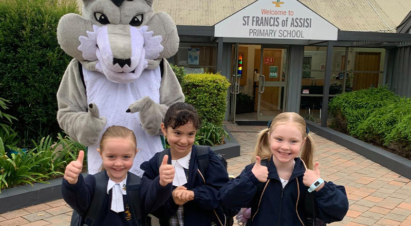 School mascot surrounded by children at St Francis of Assisi Catholic Primary School Glendenning