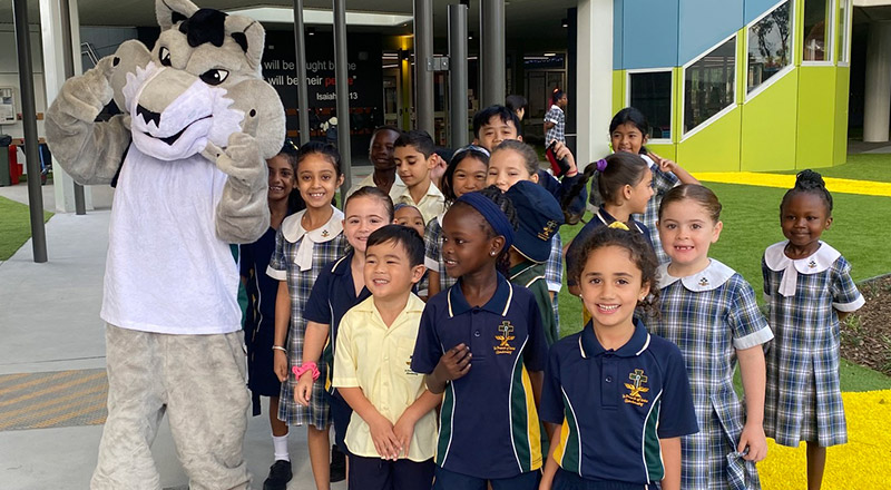School mascot surrounded by children at St Francis of Assisi Catholic Primary School Glendenning