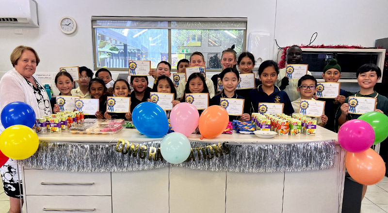 Children celebrating receiving an award at St Francis of Assisi Catholic Primary School Glendenning