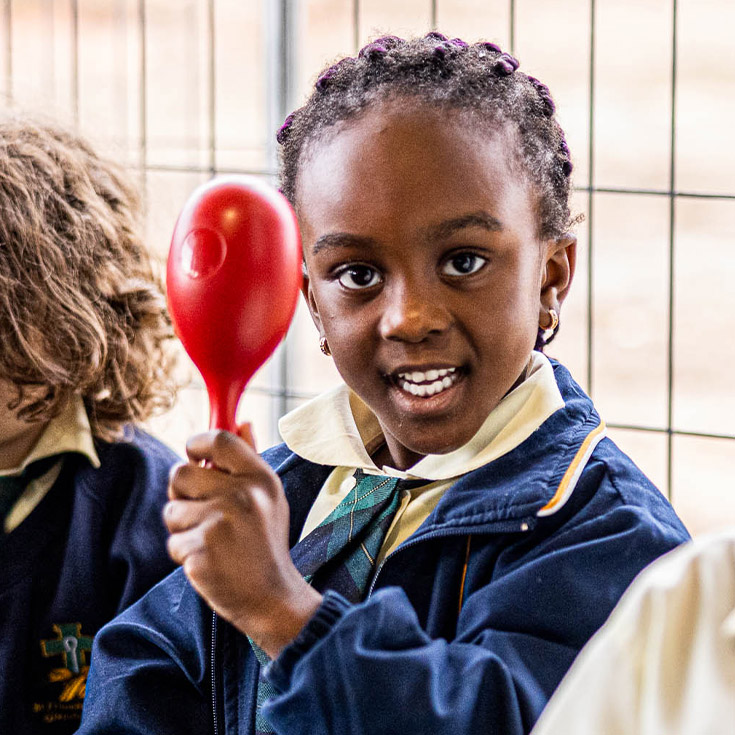 Student holds percussion instrument at St Francis of Assisi Catholic Primary School Glendenning