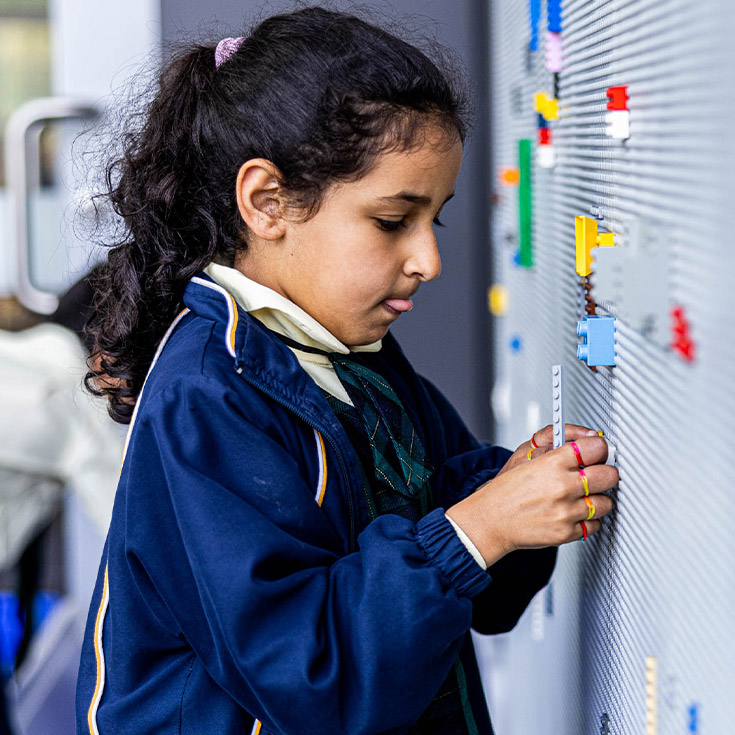 Child at lego wall at St Francis of Assisi Catholic Primary School Glendenning