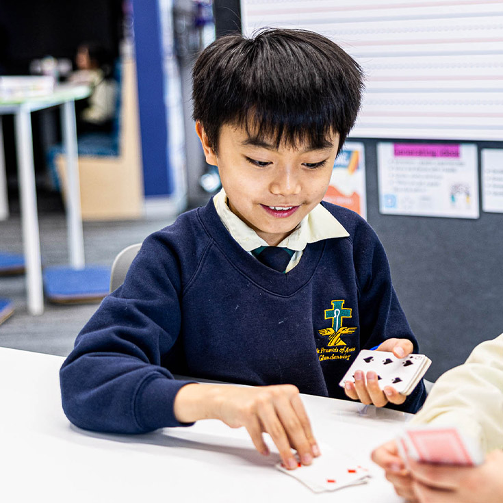 Child playing cards at St Francis of Assisi Catholic Primary School Glendenning