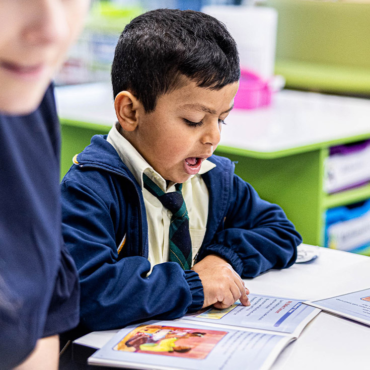 Student enthusiastically reading at St Francis of Assisi Catholic Primary School Glendenning