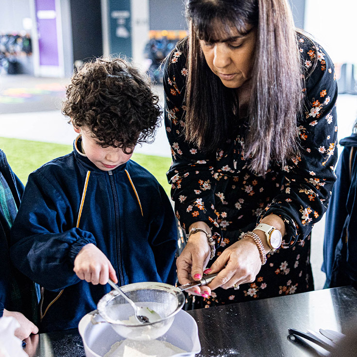 Teacher and student cooking at St Francis of Assisi Catholic Primary School Glendenning