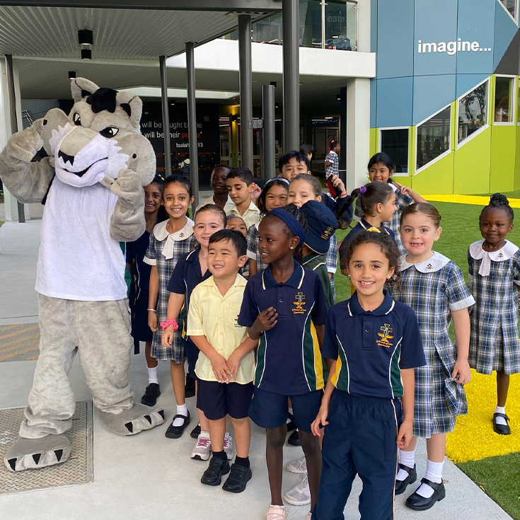 School mascot surrounded by children at St Francis of Assisi Catholic Primary School Glendenning