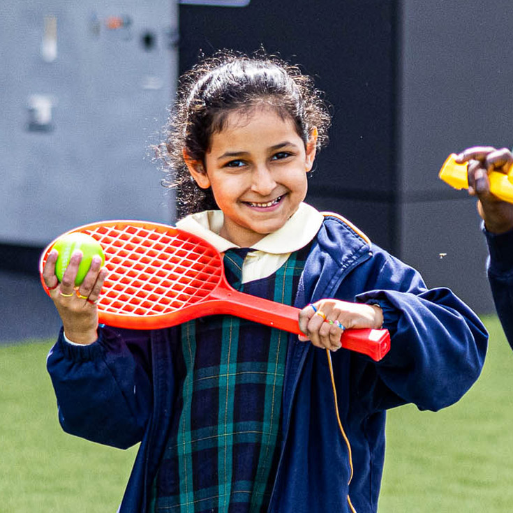 Student with tennis racket at St Francis of Assisi Catholic Primary School Glendenning
